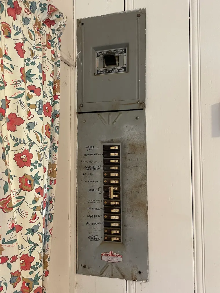 An open residential electrical panel showing rows of labelled circuit breakers.